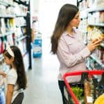 Femme avec sa fille au supermarché qui regarde la composition d'un produit