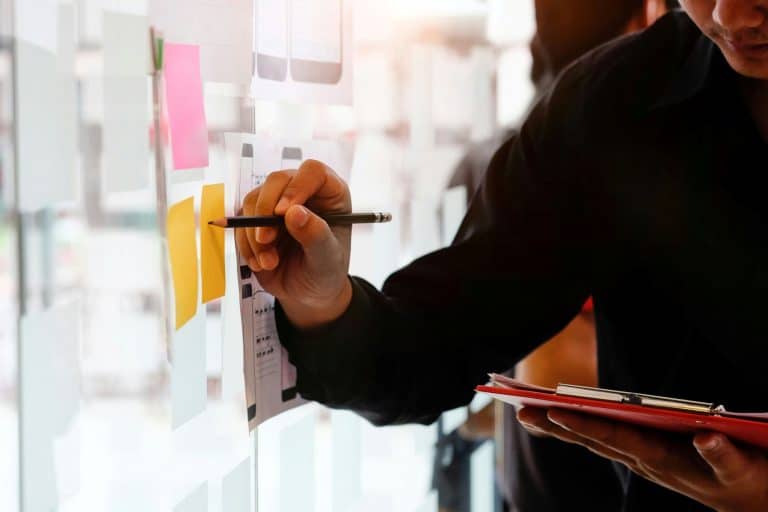 Photo illustrative d'une personne écrivant sur un post-it