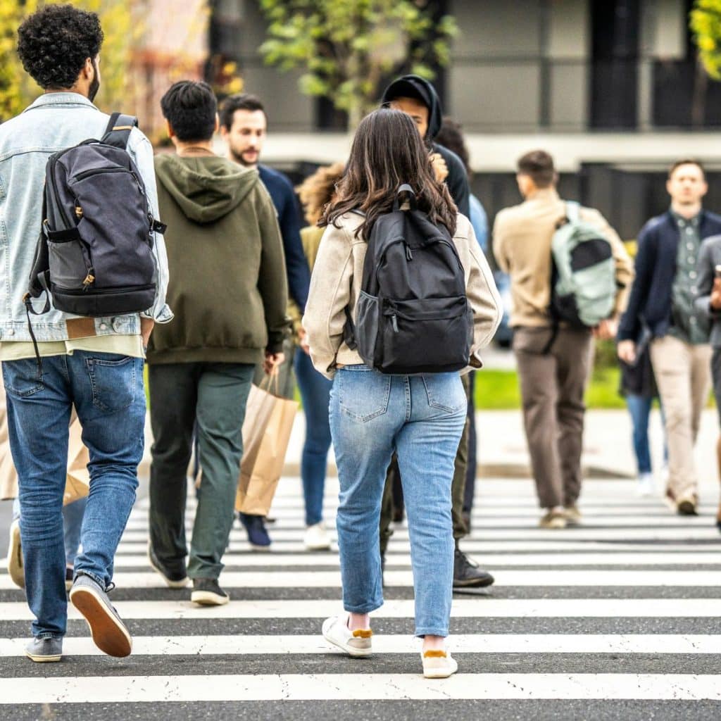 Personnes de dos traversant un passage piéton