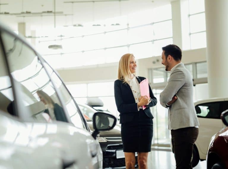 Personnes discutant dans une concession auto
